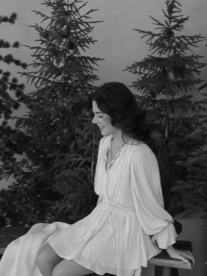 Sofía sonriendo en la banca, en blanco y negro